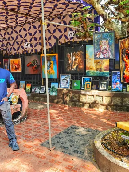 A proud moment, standing at my stall during the KALAPARBA art event. My paintings are displayed for everyone to see, featuring a mix of animal portraits, spiritual art, and cultural pieces.