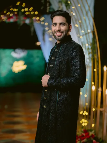 A stylish portrait of the groom, Kartik, looking sharp in his black sherwani.