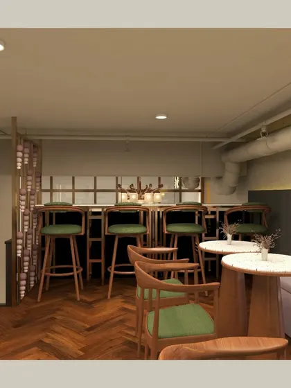 A cozy seating area in the bakehouse, featuring a mix of bar-height stools and a comfortable pink banquette. The herringbone wood flooring adds a classic, warm touch to the space.