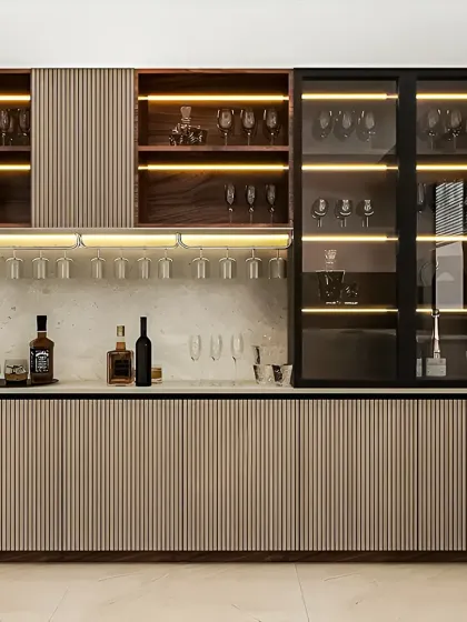 This custom bar and crockery unit showcases our expertise in modular furniture. We combined ribbed wood textures, a marble backsplash, and integrated LED lighting to create a sophisticated storage and display solution for glassware and beverages.