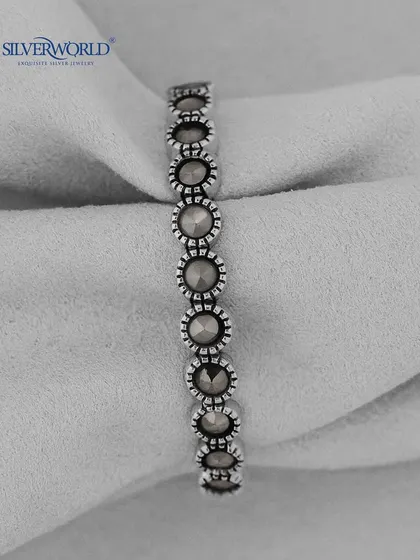 A vintage-style silver ring with a series of connected, marcasite-studded circular motifs. This eternity band has a unique, antique feel.
