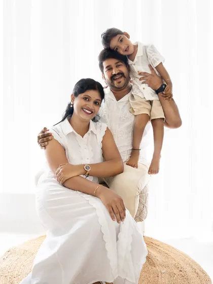 A happy family of three. The son on his father's shoulders adds a playful element to this classic portrait.