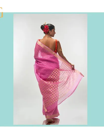 A reverse angle of the mystic pink saree, highlighting the sheer quality of the organza and the shimmer of the gold zari.