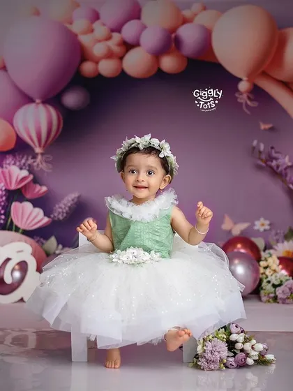 Celebrating her first birthday in style with a beautiful floral and balloon setup. This little princess is ready for her sweet and smashing moment.