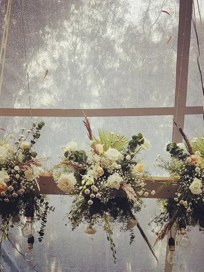 Another view of our custom-made floral chandeliers. These installations are perfect for adding a focal point to a rustic or industrial-chic event, blending natural beauty with modern lighting.