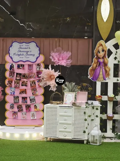A 'Fairytale Journey' photo board displaying pictures of the birthday girls, next to a Rapunzel cutout and a charming white dresser used for desserts.