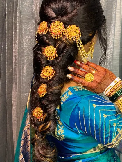 A detailed view of her South Indian temple-style hair accessories on a modern messy braid.