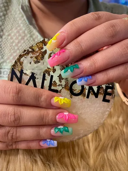 A closer look at the multi-colored 3D floral nails. Each petal is carefully shaped to create a stunning, dimensional effect that makes the design pop.