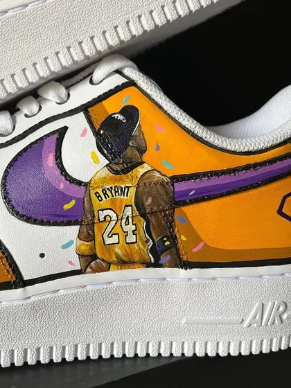 A close-up of the Kobe Bryant tribute sneakers, showing the detail on his jersey and the confetti background.