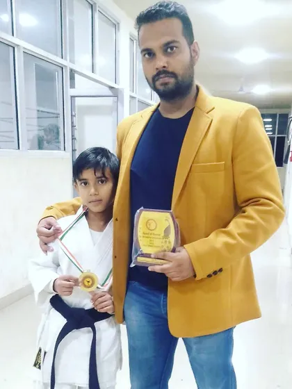 My little brother after winning a medal, with our guru. Seeing him succeed is a proud moment for the whole family.