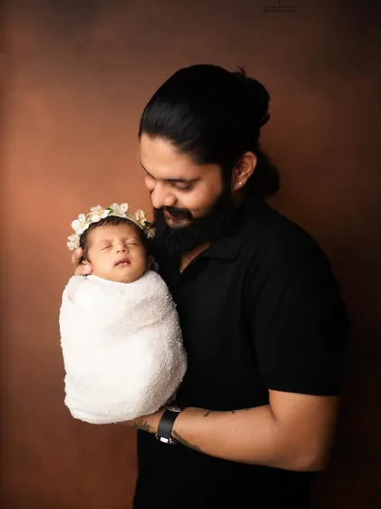 A father holding his whole world. This simple portrait focuses on that powerful, protective bond between a dad and his newborn.