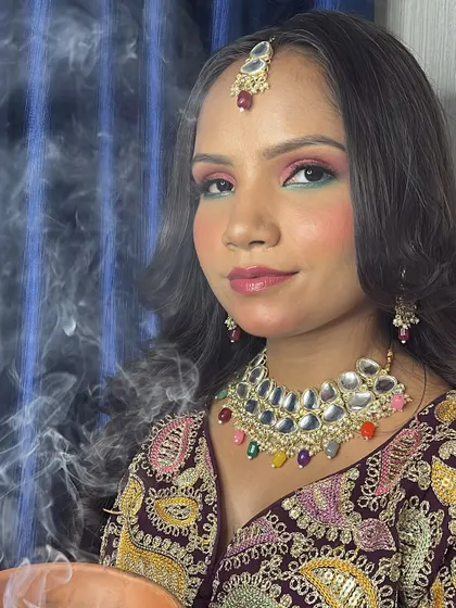 A close-up of the glass skin makeup look. The skin is luminous and the eye makeup is a beautiful blend of pink and green.