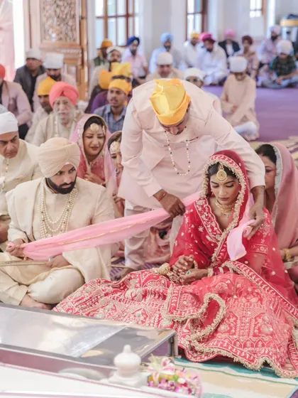 A key moment in the Anand Karaj ceremony, where the bride's father places the groom's sash in her hand, symbolizing giving his daughter away.