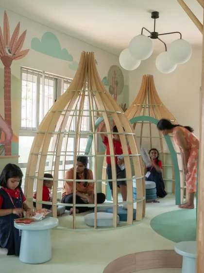 Children and teachers enjoying the reading pods in the nursery library. These structures provide a cozy, semi-enclosed space that feels like a secret hideout, perfect for quiet reading or sharing a story.