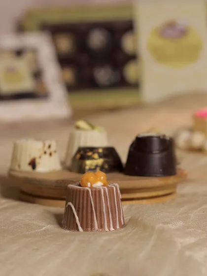 This image highlights our caramel-filled soft-centered chocolate, decorated with white chocolate drizzle. The soft, gooey caramel center is a delightful surprise.