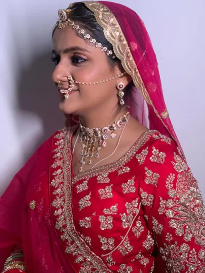 A side profile of the bride, showcasing her intricate nath and matha patti. The makeup is kept clean and elegant to let the traditional jewellery shine.