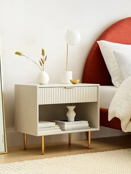 This modern nightstand features a roomy drawer with a fluted wood front and an open shelf for display. The lacquered finish and delicate metal legs add a touch of texture and shine to your bedside.
