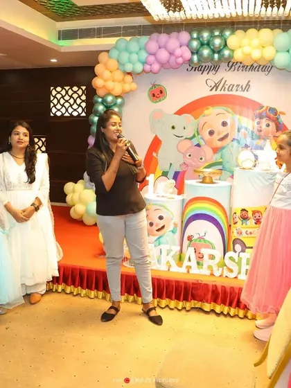 An emcee engaging with the kids at a Cocomelon party. Hiring an emcee is a great way to structure the party with games and activities, ensuring everyone has a fantastic time.