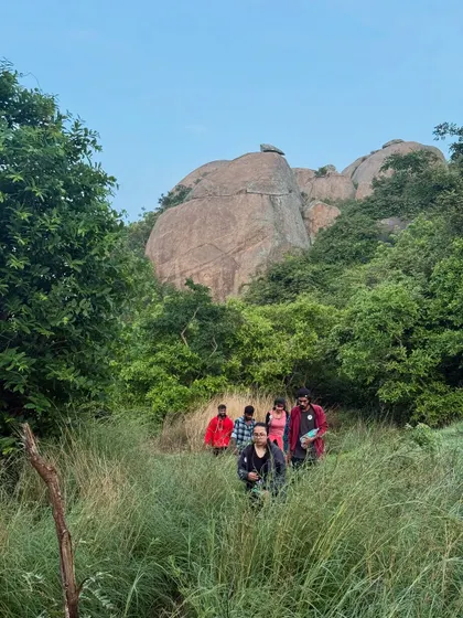 Our group trekking through the bushy trails of Uttari Betta, with the unique rock formations of the hill in the background.