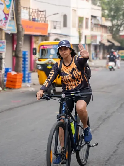 A cyclist waves to the camera during the Tour de Forest, capturing the fun and friendly atmosphere of the event.