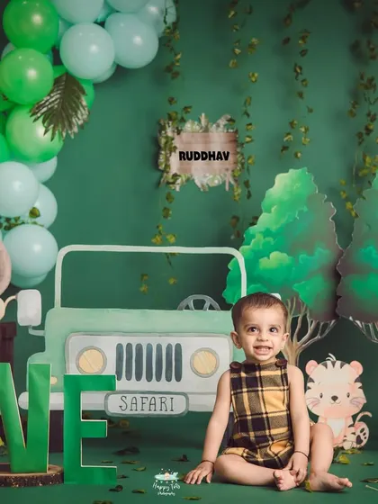 Let's go on a safari. This setup features a cool jeep cutout, friendly cartoon animals, and a lush green backdrop for a wild one's birthday adventure.