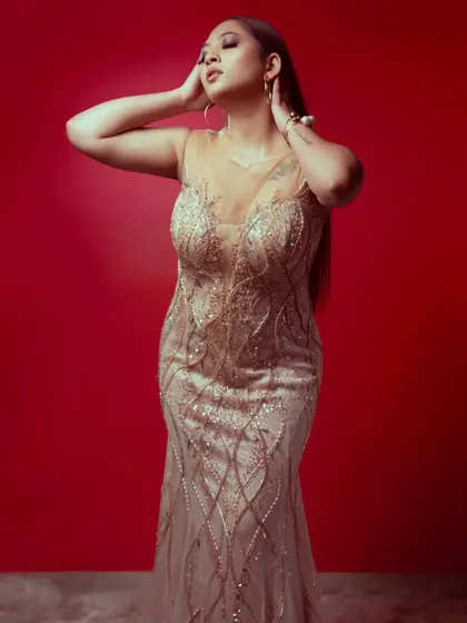 This pose highlights the graceful lines and shimmering fabric of the champagne gold gown, a truly elegant rental choice.