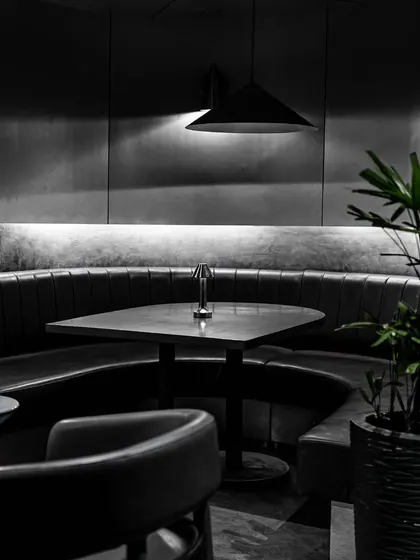 Step into a world of modern luxury and sophistication at our chic, monochromatic Lair. This view shows one of our comfortable booths, perfect for a relaxed evening.