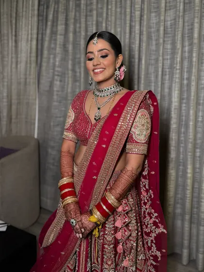 Anusha is all set to shine at her reception. We created the regal look she envisioned with matte eyes, glossy lips, and muted cheeks, perfectly complementing her stunning red outfit.