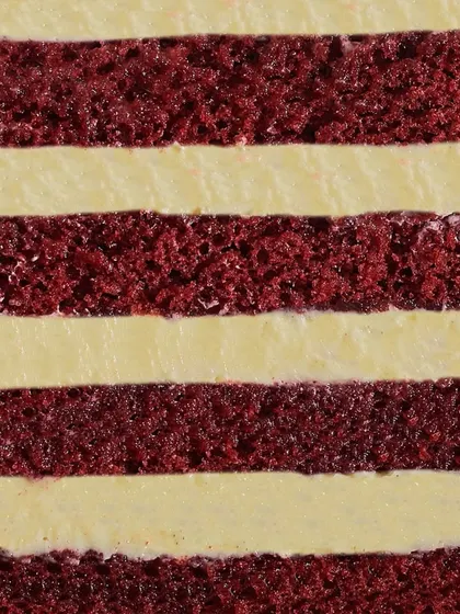 A close-up of the heart of my Red Velvet cake. You can see the distinct, soft layers of red velvet sponge alternating with smooth, tangy cream cheese frosting.