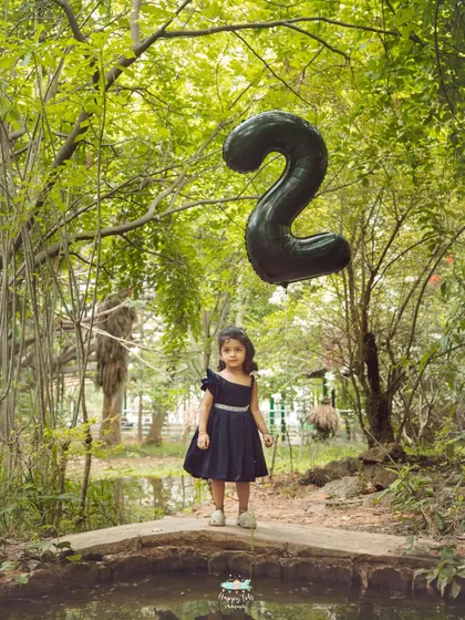 This little girl's second birthday portrait is so magical. The oversized balloon and the enchanting park setting make for a truly special memory.
