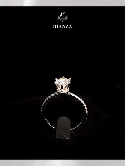 Another view of the solitaire ring with a hidden halo, showcasing the delicate diamond-studded band and the beautifully raised setting of the central stone.
