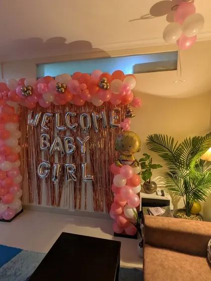 Another angle of the 'Welcome Baby Girl' decor, showing how the setup fits into a home's living area next to the sofa.