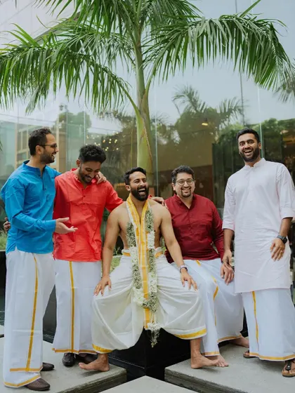A relaxed and happy portrait of the groom and his groomsmen, all dressed in traditional South Indian attire.