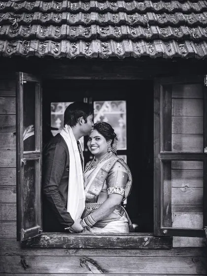 A classic black and white portrait of the couple framed by a rustic window. This timeless shot feels intimate and romantic.