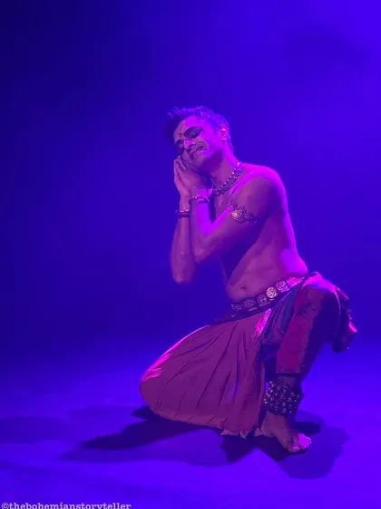 A moment of quiet reflection during 'ATAH'. The purple lighting creates a serene and contemplative mood, contrasting with the more energetic parts of the performance.