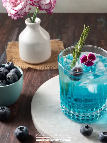 A bright and refreshing blueberry mocktail. The light, airy styling and marble background give it a clean and elegant feel, perfect for a summer menu.