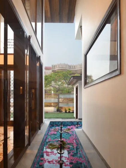 At Ashraya Residence, a modest water body with fountains runs between the temple room and the entrance corridor. It serves as a serene decorative feature, offering visual relief and a calming ambiance.