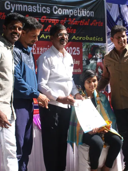 Another one of my students is recognized for her achievements at our competition, sitting with her certificate and garland.