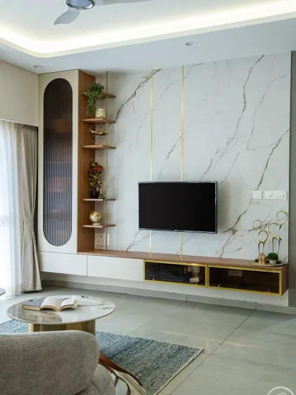 A close-up of the elegant TV unit, which features a white marble panel with gold accents, a fluted glass cabinet, and open wooden shelves. This combination of materials creates a sophisticated and modern focal point.