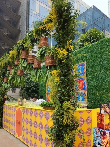 For a more playful and informal event, we can create fun, themed bars. This 'Theka' style bar uses quirky Bollywood posters, patterned designs, and a canopy of greenery to create a relaxed and engaging atmosphere.