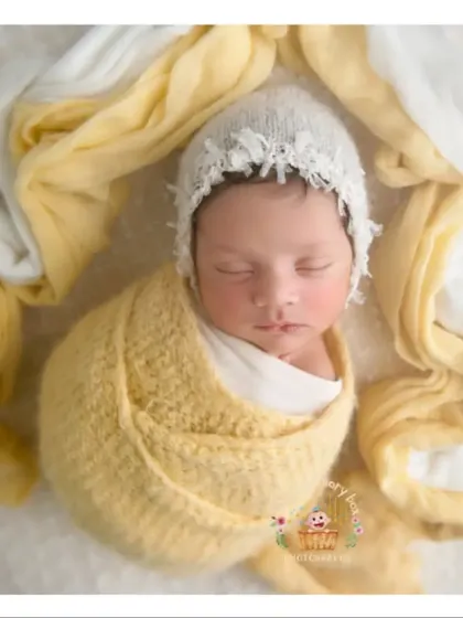 This little sunflower is wrapped in a beautiful yellow knit. The simple white background makes the color pop and keeps the focus on the baby.
