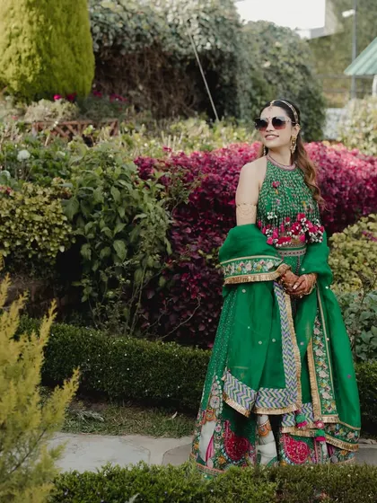 The bride, looking effortlessly chic in her green lehenga and sunglasses, enjoying the sun at her Ooty mehendi.