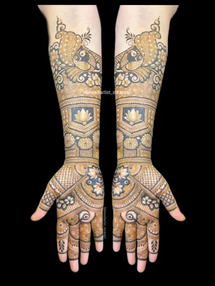 A full view of a classic bridal design combining popular motifs. The forearms feature prominent peacocks, while the palms have a floral and geometric pattern.