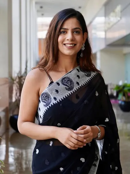 A close-up portrait in the black saree. The intricate silver work on the border adds a touch of subtle sophistication.