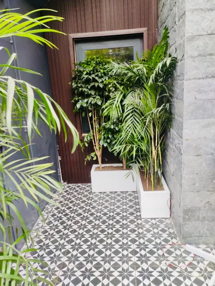 A contemporary style terrace garden using a black and white color scheme. The beautiful handmade tiles enhance the look, and the planters add greenery, making the small space feel more open.