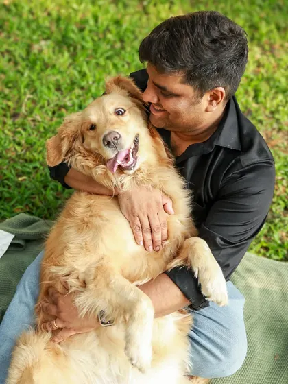 Just look at that happy face! This Golden Retriever is clearly loving the cuddles from her dad during our outdoor shoot. It's pure, unfiltered joy.