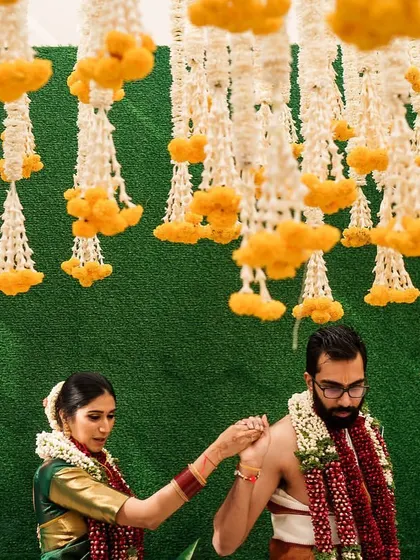 A beautiful moment from a wedding that thoughtfully amalgamated two different cultures. The ceiling is adorned with traditional garlands of marigold and jasmine, creating a fragrant and visually stunning canopy.