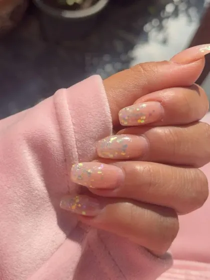 Sheer gel extensions with iridescent, confetti-like glitter embedded within the nail for a subtle, multi-colored sparkle.
