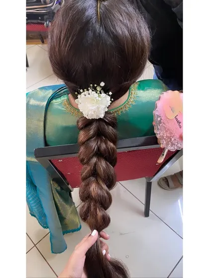 A classic pull-through braid, which gives a voluminous and intricate look, finished with a single fresh flower and baby's breath.