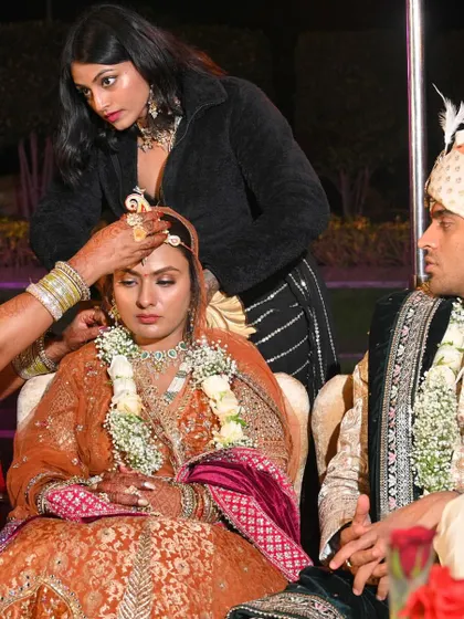 As a stylist, I'm often hands-on during the most important moments. Here, I'm assisting with the bride's wedding ceremony rituals, ensuring she looks and feels perfect.